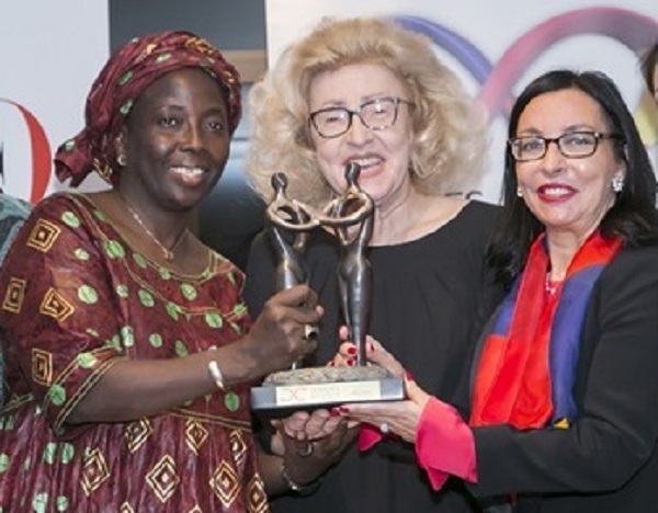 Julie Cissé poses with the award she received for her dedication to political participation, economic empowerment, and women's leadership.