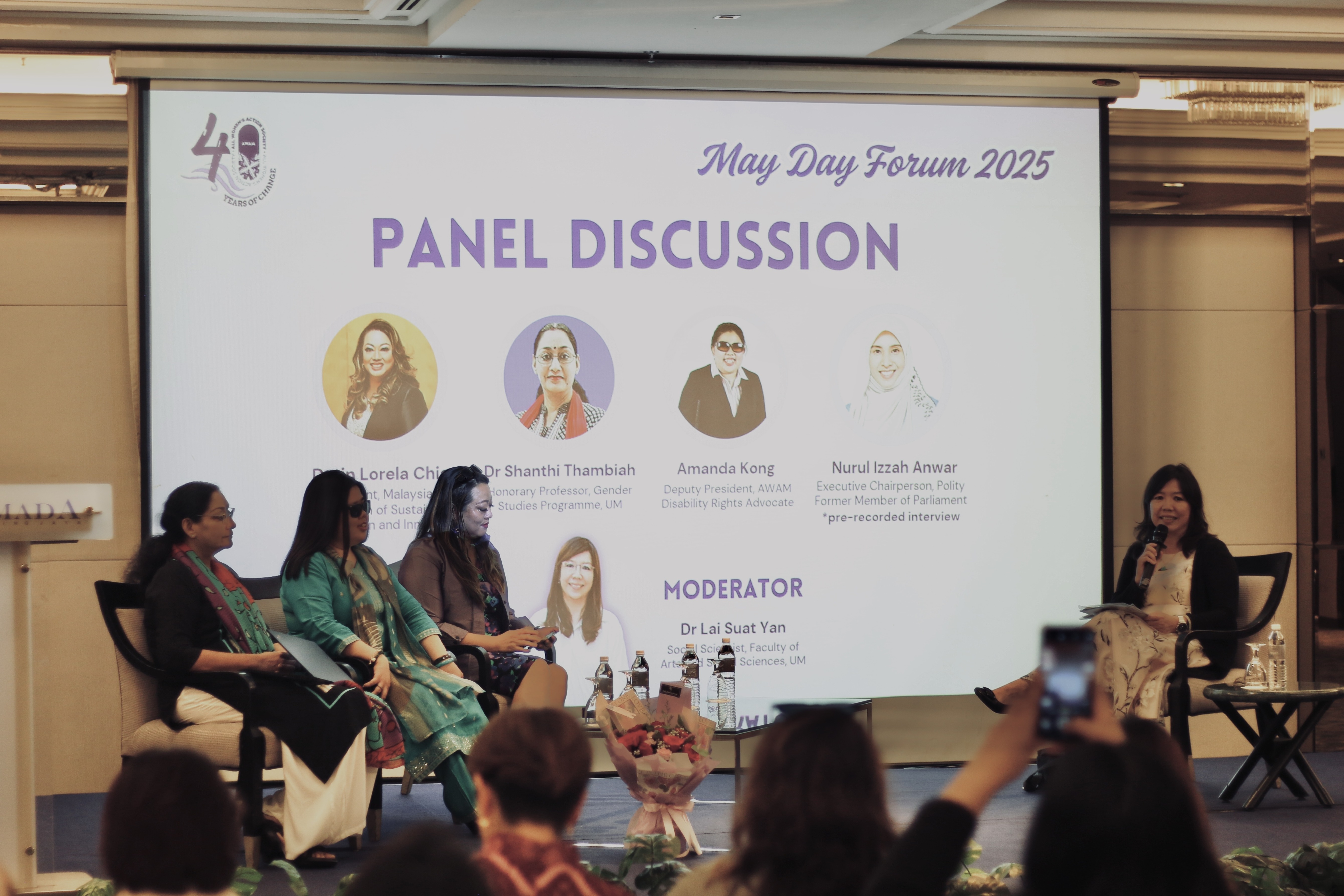 Panelists on stage at AWAM's May Day Forum