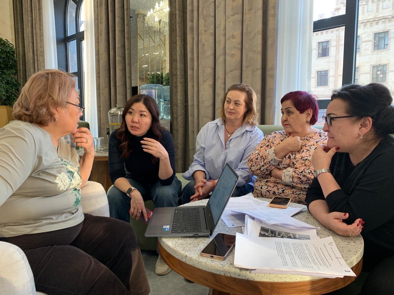 5 women at an SWRC regional training sitting in a circle discussing lessons learned