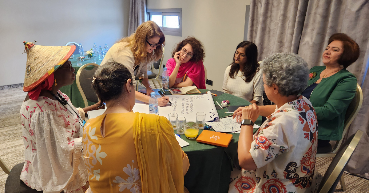 Women gather for a transnational meeting at a table discussion
